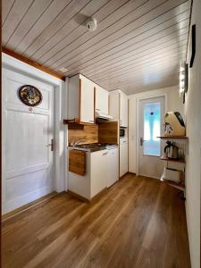 因特拉肯因特拉肯玛丽亚公寓的厨房铺有木地板,配有白色橱柜。