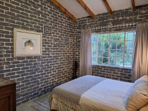 雾观Numbi Hills Self-Catering的卧室设有砖墙、一张床和一个窗户