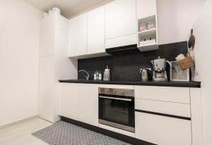 萨罗C-Apartment Lake Garda的厨房配有白色橱柜和炉灶。
