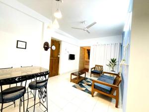 科尔瓦Luxurious 1BHK with a Pool AniRah Homes in Colva的厨房以及带桌椅的起居室。