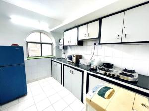 科尔瓦Luxurious 1BHK with a Pool AniRah Homes in Colva的厨房配有白色橱柜和蓝色冰箱。