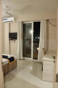 马图拉Hotel Shyam Basera的一间卧室设有一张床和一个阳台的窗户。