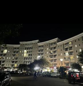 马图拉Hotel Shyam Basera的夜间与骑车者一起建造大型公寓大楼