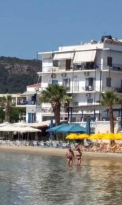 阿吉亚玛丽娜斯韦特兰娜&米哈利斯绿洲大酒店的两个人站在海滩的水面上