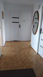 华沙Uroczy apartament z bezpłatnych parkingiem的一间设有白色门和镜子的房间