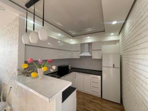 埃里温Apartment in Tumanyan street的厨房配有白色橱柜和白色冰箱。