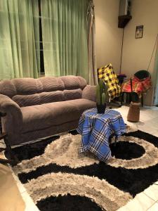 帕拉马里博Room in Guest room - Logerthine Cambridge Suriname的带沙发和仙人掌的客厅