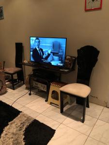 帕拉马里博Room in Guest room - Logerthine Cambridge Suriname的客厅配有平面电视和椅子。