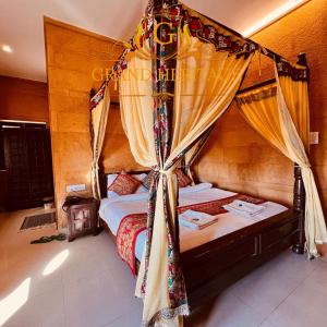 斋沙默尔Hotel Grand Heritage Jaisalmer的一间卧室配有带窗帘的天蓬床