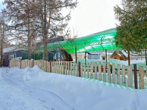 DzhergalanDolinka Lodge的房屋前有绿色屋顶的围栏