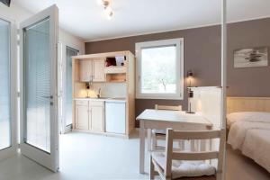 博尔索-德尔格拉帕Residence Gonda&Giuliano的一间带一张床和一张书桌的卧室和一间厨房