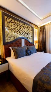 安塔利亚Can Adalya Palace Hotel的一间卧室配有一张大床和大床头板