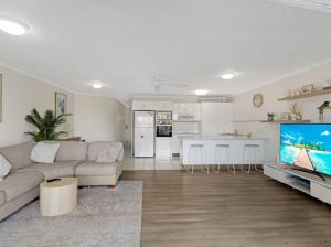 赫维湾里维埃拉公寓的带沙发和电视的客厅以及厨房。