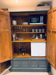 贝德福德2 Beds & living in our idyllic country Cottage的厨房配有微波炉和冰箱。