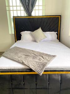 LuisiLuckysmallie_villa的一张带黑色床头板和白色枕头的床