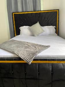 LuisiLuckysmallie_villa的一张带木架、白色床单和枕头的床