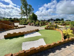 南塞尔尼Bluebell Lodge, Dog Friendly的一个带人工草坪和挡土墙的花园
