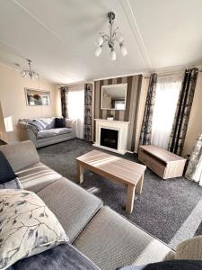 南塞尔尼Bluebell Lodge, Dog Friendly的客厅配有沙发和桌子