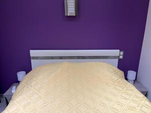 加普Villa chaleureuse Centre ville - Parking privée的一间卧室配有一张紫色墙壁的床