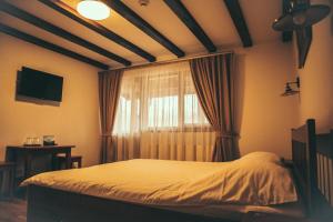 阿尔杰什河畔库尔泰亚Dorul Pescarului的一间卧室配有床和带窗帘的窗户