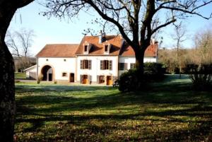 Gîte Au Moulin de Bougnon Calme et Dépaysement en Haute-Saône的院子中一棵树的白色大房子