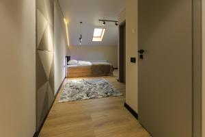 赫梅利尼茨基Discovery Garden apartments的走廊上设有一张床和地毯的房间