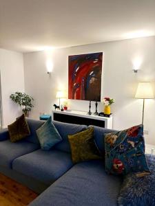 伦敦Luxury apartment in Canary Wharf的客厅里一张蓝色的沙发,上面有绘画作品