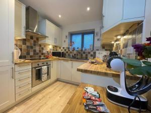 彭里斯Lake District romantic get away in 1 acre gardens off M6的厨房铺有木地板,配有白色橱柜。