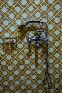 WakisoCrown Inn Bulindo的浴室墙上的淋浴头