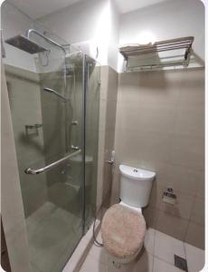 马尼拉Condotel-Shore 2 Residences MOA的一间带卫生间和玻璃淋浴间的浴室