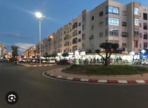 阿加迪尔Appartements à AGADIR 10min de la plage的大街上,在晚上,大建筑前