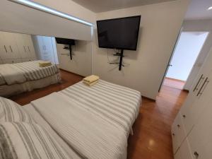 利马Espacio Luxury Apartments - Calle Independencia, Miraflores的客房设有两张床和一台平面电视。
