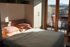 兹拉蒂博尔Goldview Apartmani的一间卧室设有一张床,享有阳台的景色