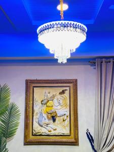 伊斯兰堡Viceroy Royal Hotel Apartment Islamabad的挂在墙上的一幅画,挂有吊灯