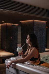纳尔瓦Narva Hotell & Spaa的坐在浴缸里喝着饮料的女人