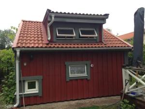 乌普萨拉Lilla Gäststugan的红色的房子,有两个窗户和屋顶