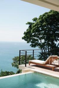 乌维塔SOL e MAR的一个带椅子和床的游泳池以及大海