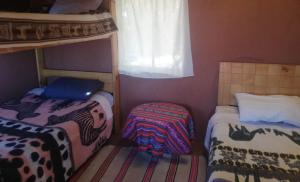 HuillanopampaBLUE SKY Lodge Taquile的小房间设有两张床和窗户