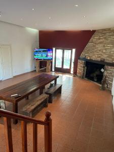 蓬塔因迪奥casa de campo的客厅配有木桌和壁炉