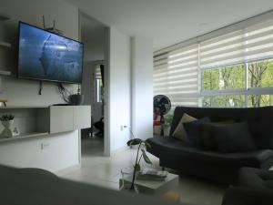 萨瓦内塔Apartamento nuevo, próximo al metro y CC Mayorca的客厅配有黑色沙发和平面电视。