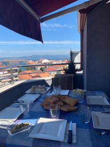 格罗韦Apartamento Mar do Grove的阳台上摆放着带食物盘的桌子