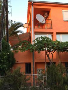 尤塔哈Holiday home Orange family apartments的一座橙色的建筑,阳台上装有卫星