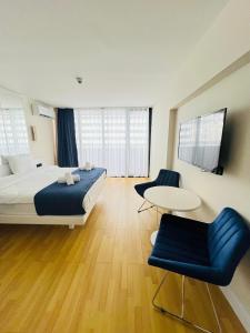 巴统Elegance Sea Views Apartments in Orbi City BATUMI的酒店客房带一张床、一张桌子和椅子