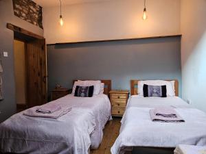 巴克斯顿Rose Cottage - Cosy cottage in Millers Dale的一间带两张带白色毯子的床的卧室