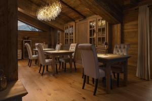锡纳亚Chalet Royal的一间带桌椅和吊灯的用餐室