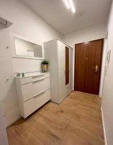 杜塞尔多夫Renoviertes Apartment inkl TG Stellplatz in Düsseldorf的厨房铺有木地板,配有白色橱柜。