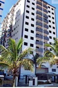 蒙加瓜Apartamento beira mar Centro da cidade WiFi grátis的一座高大的建筑,前面有棕榈树