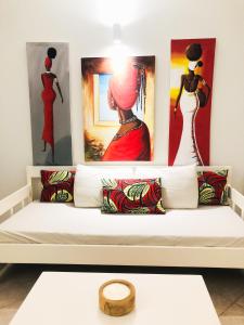 萨尔雷Boavista Beach Apartment的白色沙发、枕头和墙上的绘画