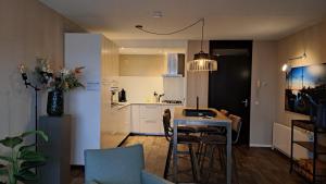 玛库姆Zuiderzeestate 35, prachtig appartement aan het IJsselmeer的厨房以及带桌椅的起居室。