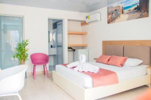 卡普兰干HOTEL PIEDRA VIVA的一间卧室配有一张床和一张粉红色的椅子